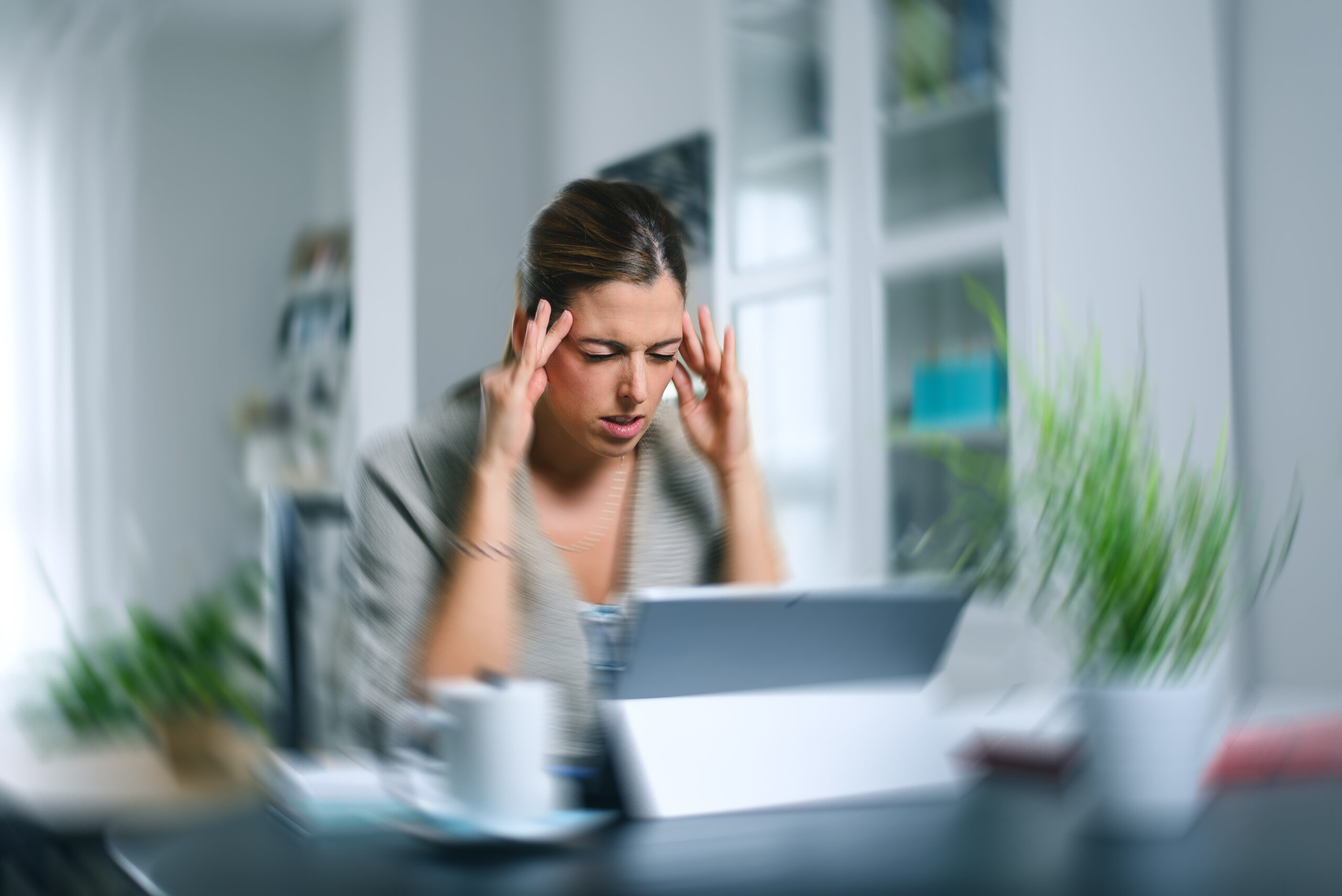 Woman feeling dizzy and sick sitting at her desk